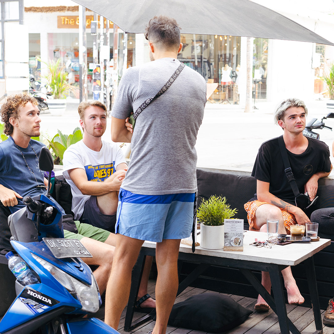 four guys sitting in bgs coffee bar outdoor seating